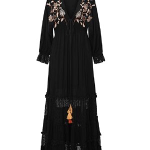 Back view of a woman in a black embroidered black and white maxi dress, highlighting its flowy design.